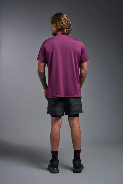 Person wearing a purple t-shirt and black shorts on a gray background