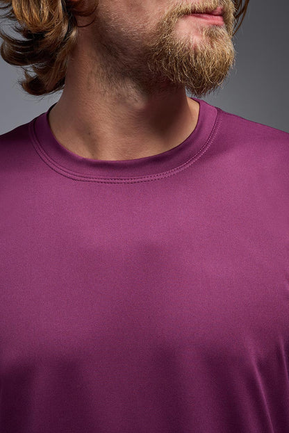 Close-up of a person wearing a purple shirt with a neutral background