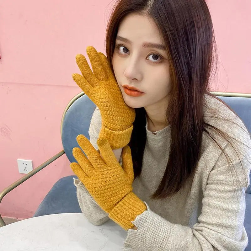 Heated Thermal Gloves model holding gloves to her face