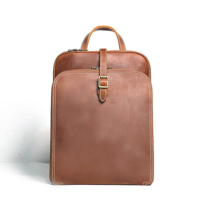Small tan leather backpack with top handle and front flap buckle closure
