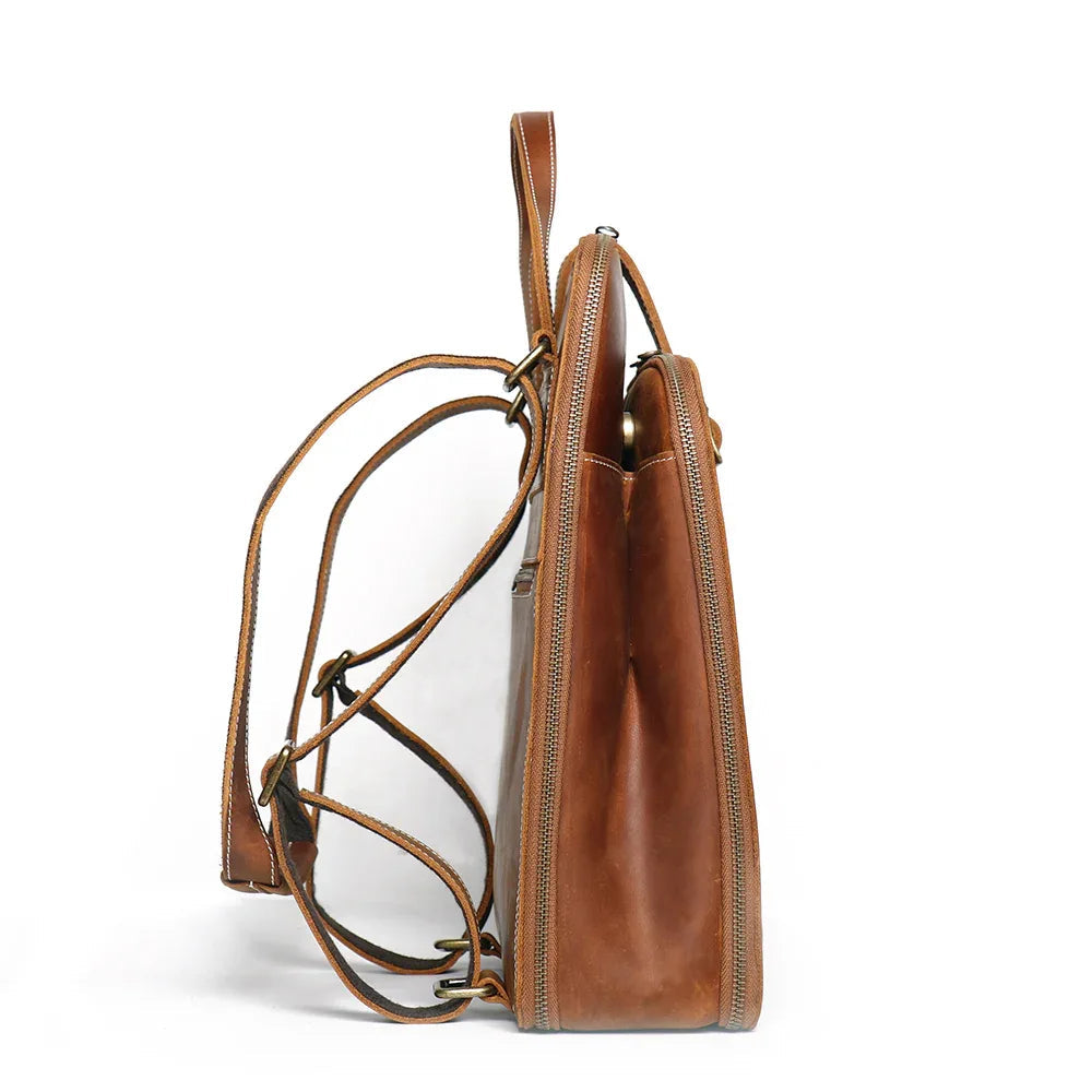 Small brown leather backpack side view with adjustable shoulder straps