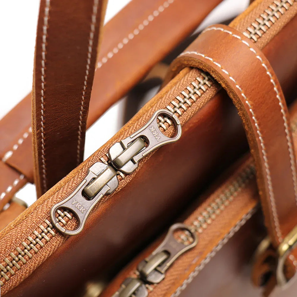 Leather backpack zipper track with metal pulls and stitched edge trim