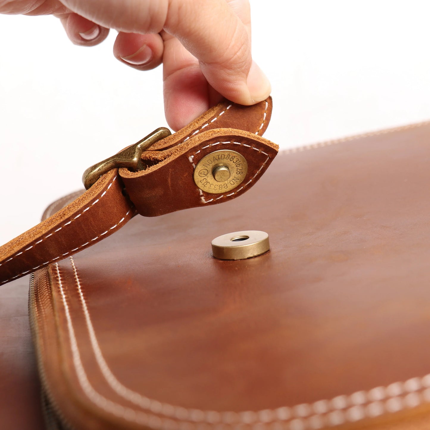 Leather backpack strap clasp with round metal snap button