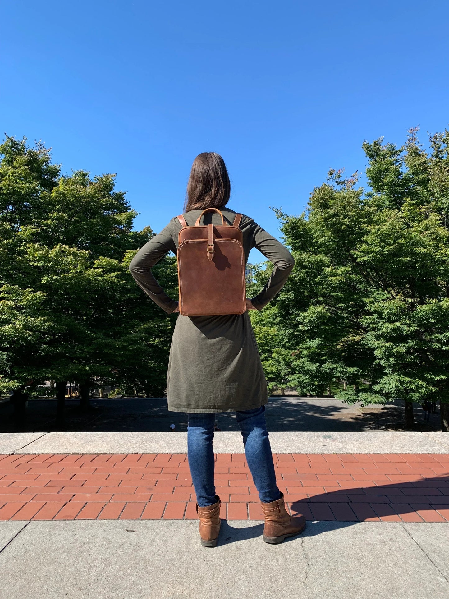 Small leather backpack on model, back view with shoulder straps