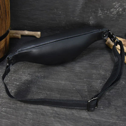 Black leather belt bag with adjustable strap and metal buckle, front zip closure.