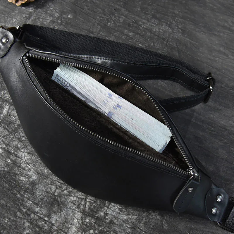 Black leather fanny pack with front zipper open, showing interior lining and pocket.
