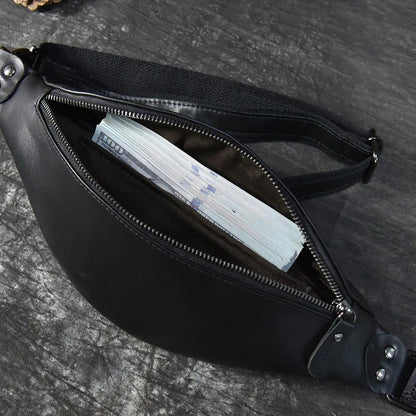 Black leather fanny pack with front zipper open, showing interior lining and pocket.