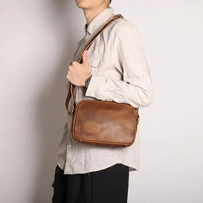 Brown leather crossbody bag back side with shoulder strap and stitched detailing