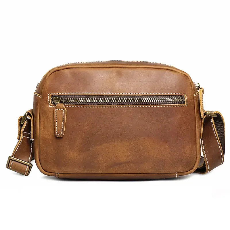 Brown leather crossbody bag front with zipper pocket panel and contrast stitching