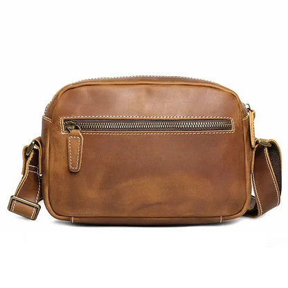 Brown leather crossbody bag front with zipper pocket panel and contrast stitching