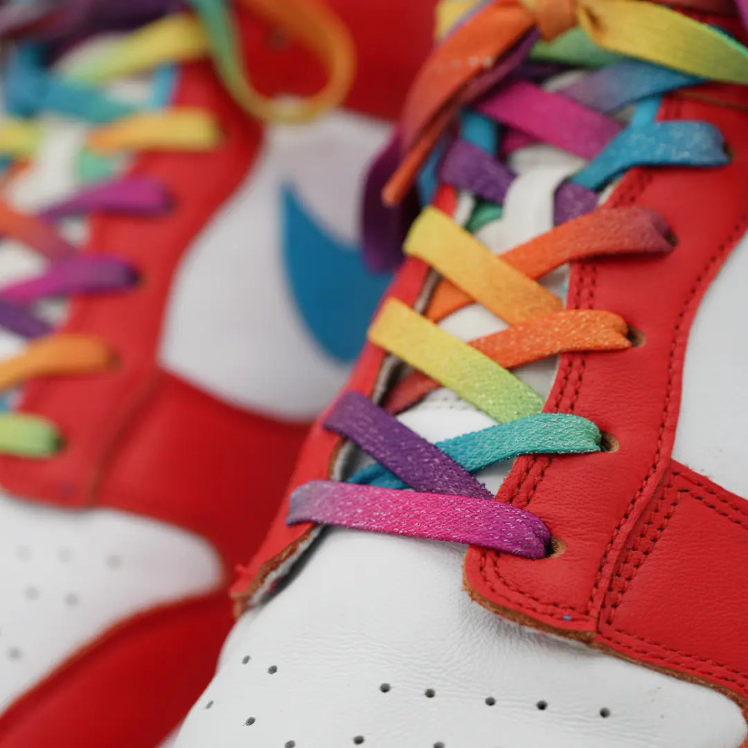 Close-up of red sneakers with multicolored laces on a blurred background