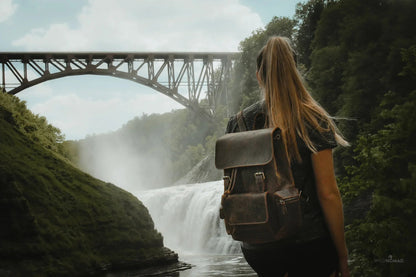Brown vintage leather backpack on back with top flap and front compartments.