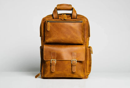 Brown leather camera backpack with two front buckled pockets and carry handle
