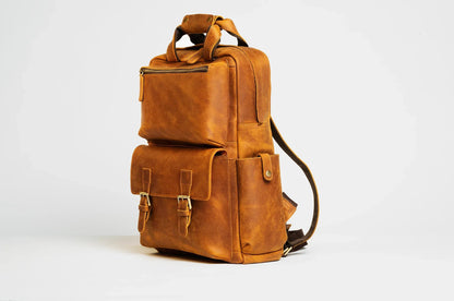 Brown leather camera backpack with two front pockets and side shoulder strap