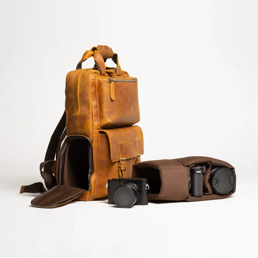 Large leather camera backpack with front flap and top handle, brown with shoulder strap