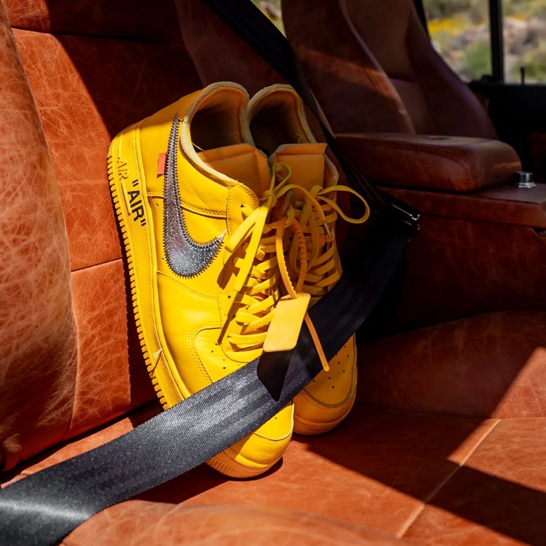 Yellow sneakers with a brand logo on a car seat