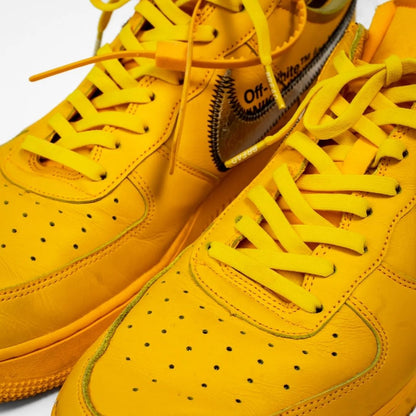 Yellow sneakers with visible branding on a white background