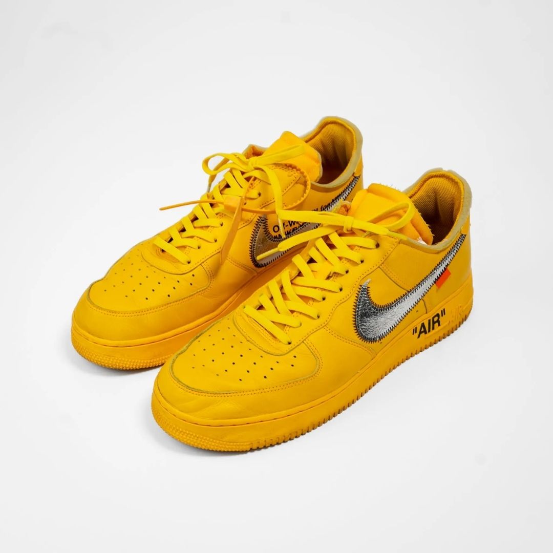 Yellow sneakers with a silver Nike logo on a white background