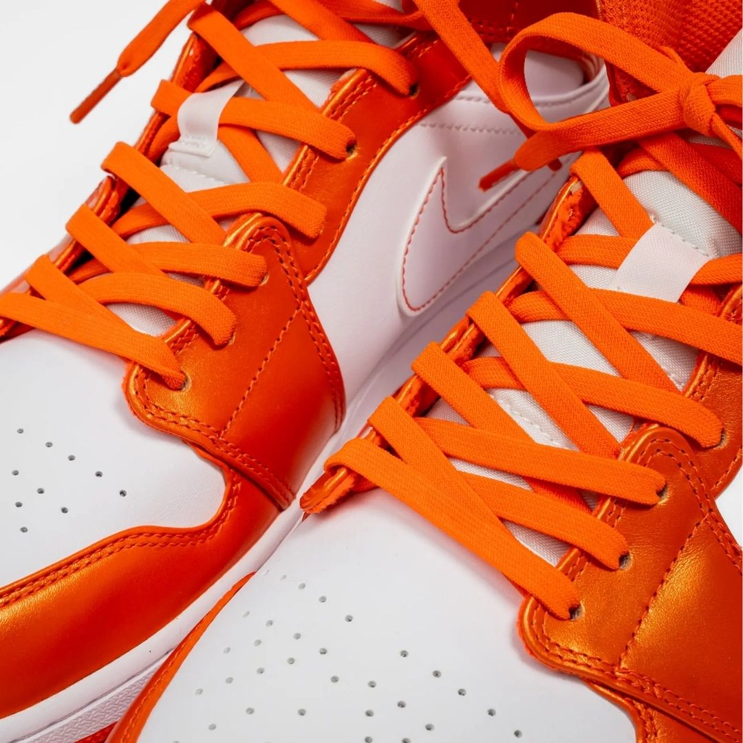 Orange and white sneakers with orange laces on a white background