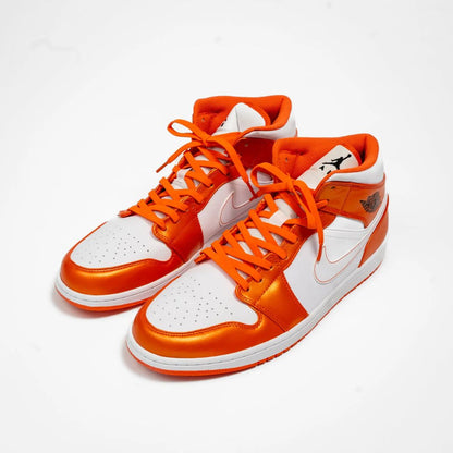 Orange and white sneakers with a brand logo on a white background