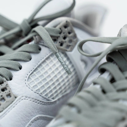 Close-up of gray sneakers with 'Bread' branding on a blurred background