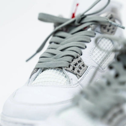 Close-up of a white sneaker with gray laces on a blurred background