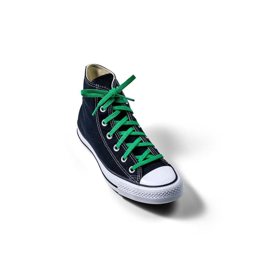 Navy blue sneaker with green laces on a white background