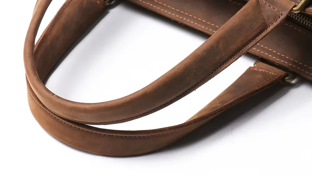 Brown leather top handle and strap with stitched edges and brass hardware