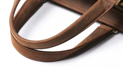 Brown leather top handle and strap with stitched edges and brass hardware