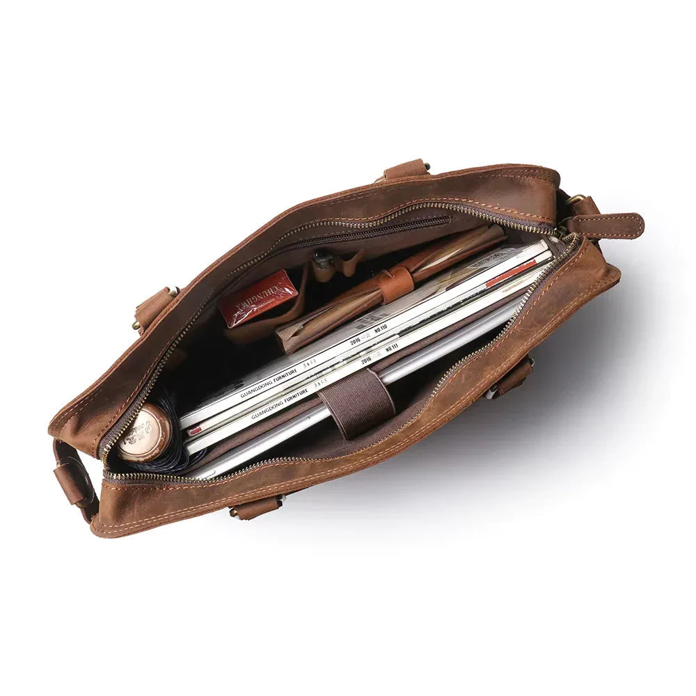 Brown leather messenger bag open to show interior divider and document slots