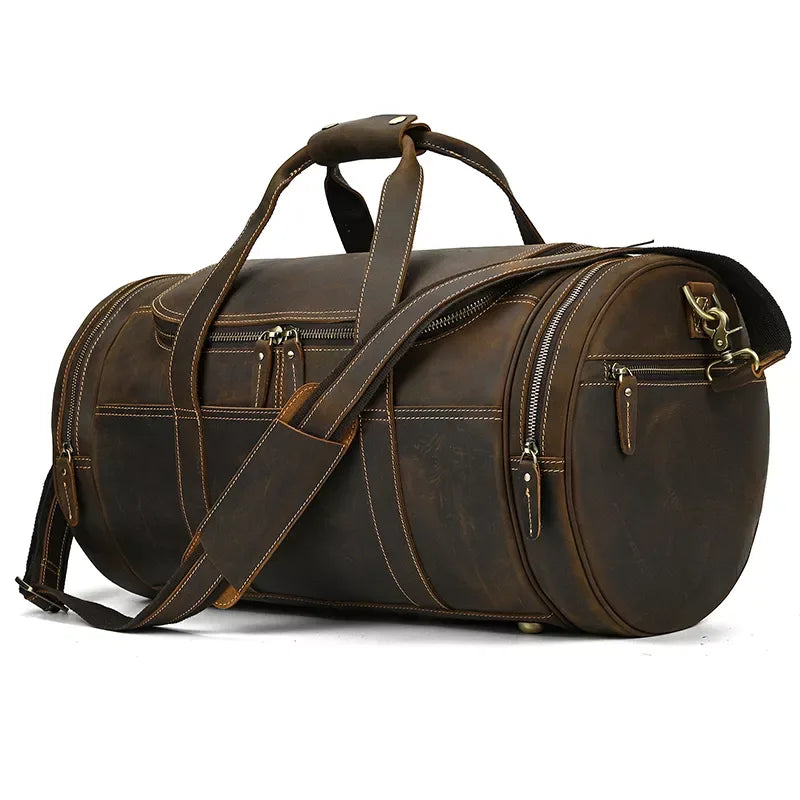 Brown round leather duffel bag with top handle, front zip pocket, and side strap.