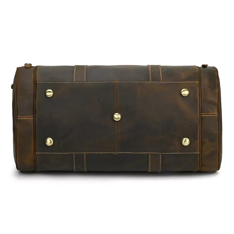 Rectangular leather duffle bag with snap-front panels and side metal stud details