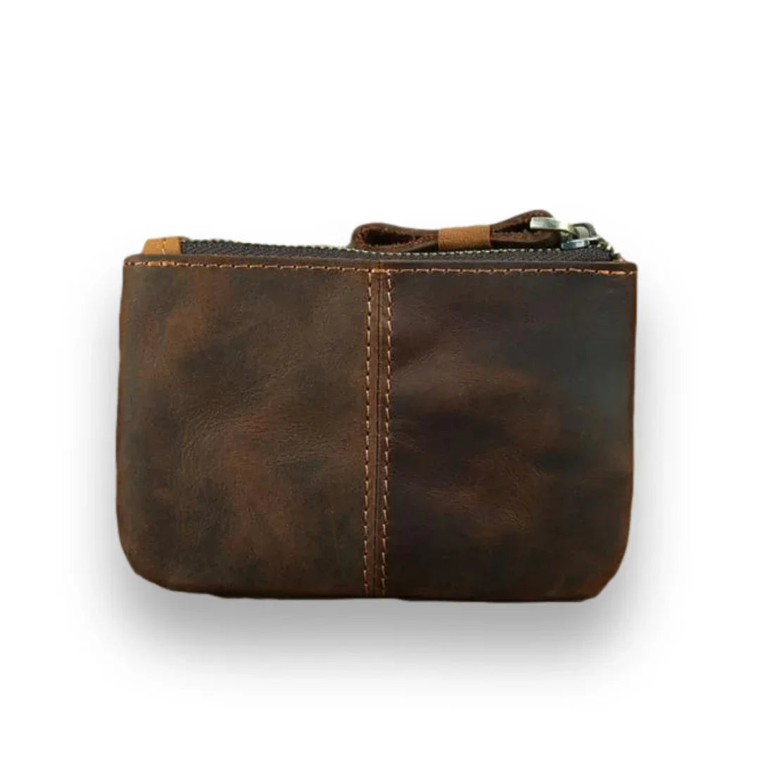 Brown handmade leather coin purse with top zipper and stitched front panel.