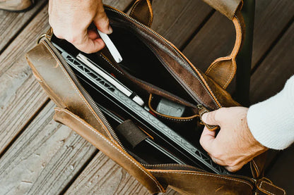 Vintage leather messenger bag open with document and card slots inside, dark brown leather