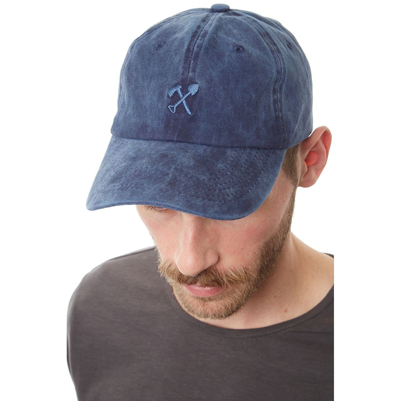 Man wearing a blue baseball cap with a logo on a white background