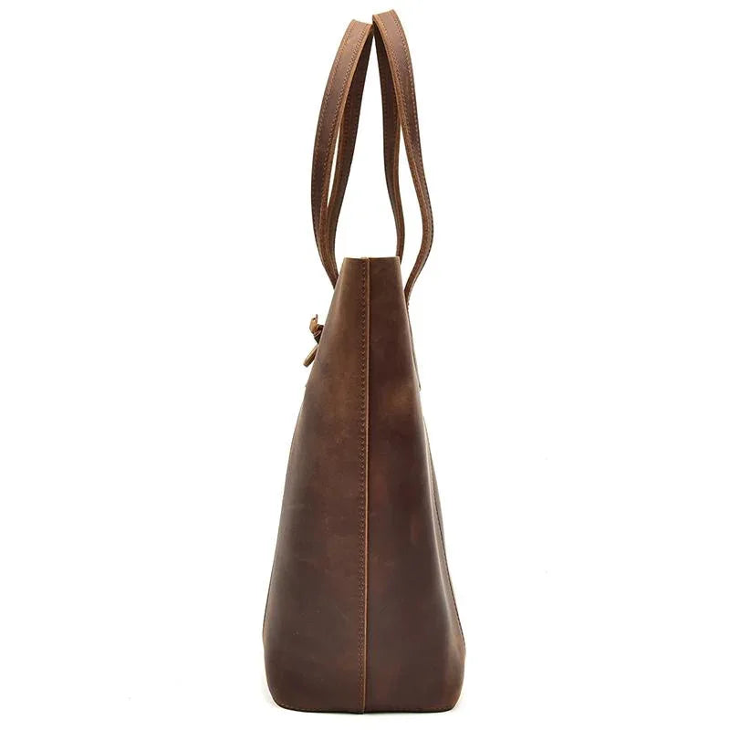 Handcrafted leather tote bag with long shoulder strap and tapered top silhouette
