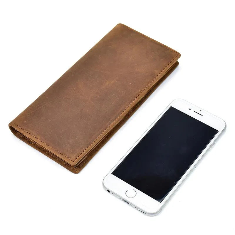 Brown leather pocket book with fold design next to a smartphone