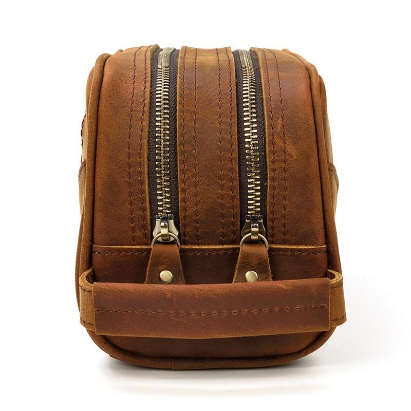 Brown leather toiletry bag back view with dual zipper tracks and snap straps