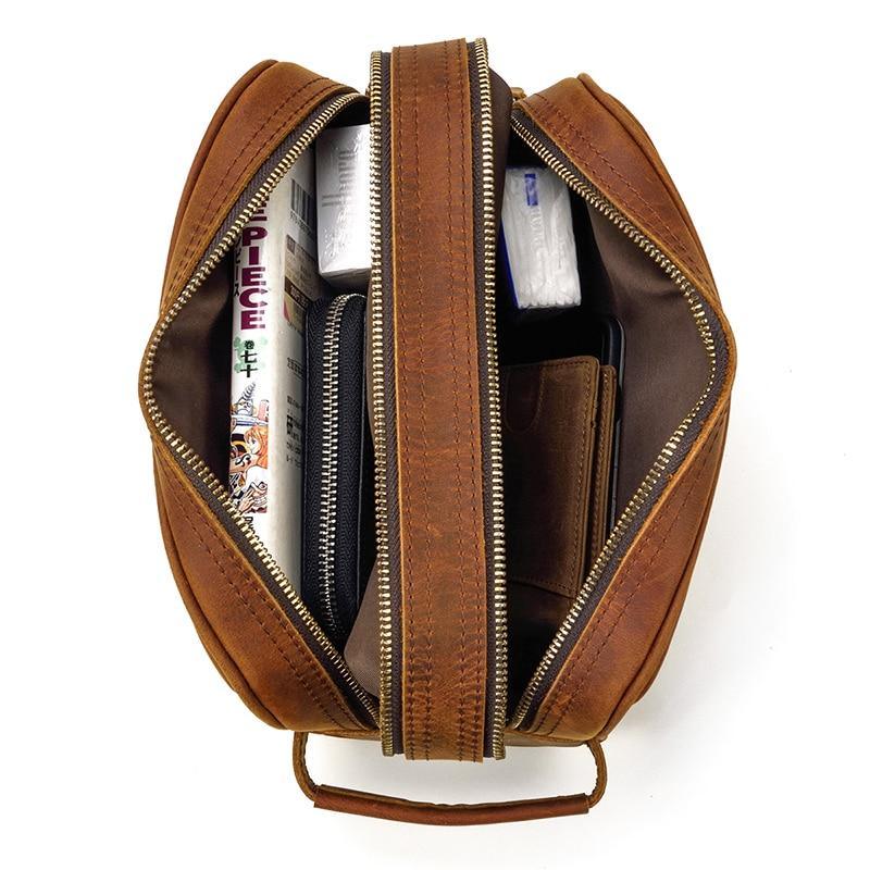 Leather toiletry bag interior view through open top; multiple zip compartments