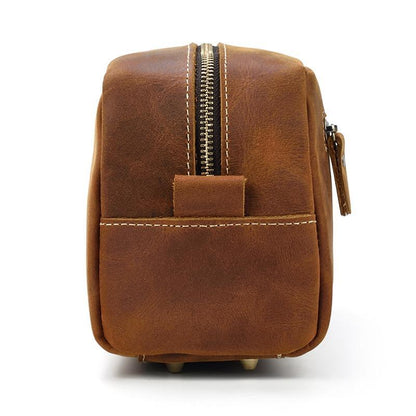 Brown leather toiletry bag back view with top zipper and hanging loop detail
