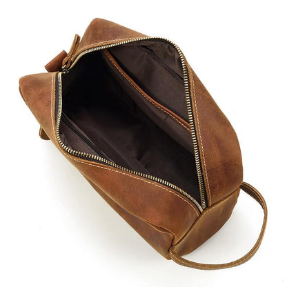 Brown genuine leather toiletry bag opened, showing inner compartments and zip pockets