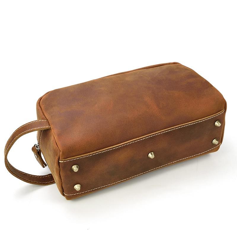 Brown genuine leather toiletry bag with riveted front base and top zip closure
