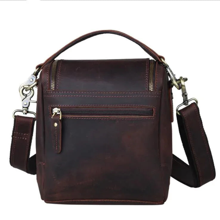 Brown leather camera bag with front zipper pocket and adjustable shoulder strap