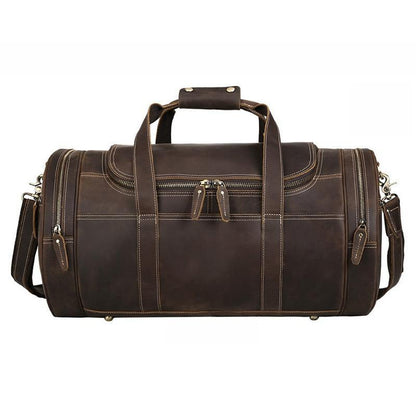 Brown leather round duffle bag with top handle, side zippers, and brass rivet accents.