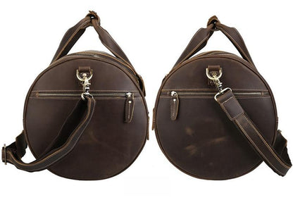 Pair of round brown leather duffel bags with zip front, crossbody strap, and metal hardware.