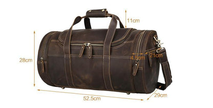 Brown leather round duffle bag with top handle, shoulder strap, and front zipper pockets.