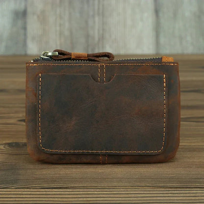 Brown leather coin purse with zipper, front pocket detail and stitched borders.