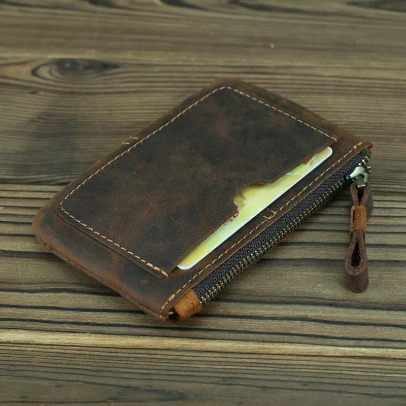 Brown leather coin purse with open card slot and zipper track, leather pull tab.