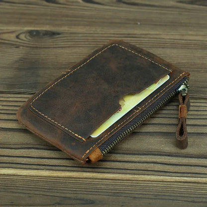 Brown leather coin purse with open card slot and zipper track, leather pull tab.