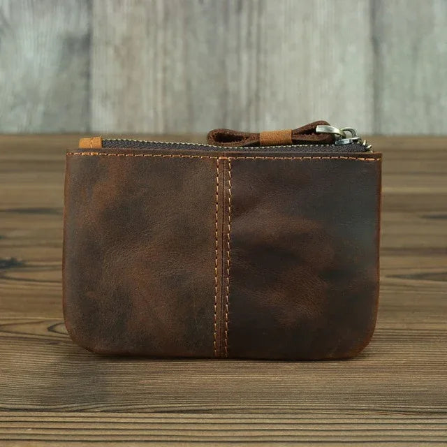 Brown leather coin purse with zipper, front panel seam and metal zipper pull.